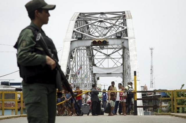 Personas miran a un soldado venezolano que hace guardia en el puente internacional de La Unión, en la frontera entre Colombia y Venezuela, en el estado de Táchira, 29 de agosto de 2015. REUTERS/Carlos Eduardo Ramirez