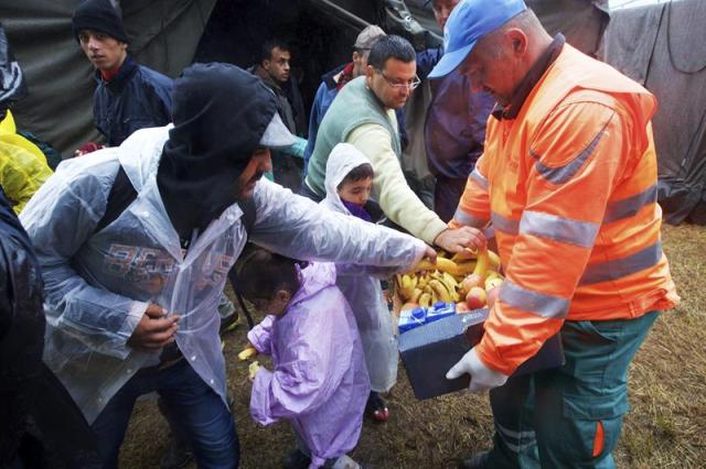 Un voluntario distribuye fruta a los refugiados en el campamento de Opatovac, cerca de Tovarnik, Croacia, hoy 29 de septiembre de 2015. Croacia no permitirá que se abra una segunda ruta de entrada de refugiados en su territorio desde el sur, por lo que se prepara para reforzar la presencia policial en la frontera de Montenegro. EFE/Str