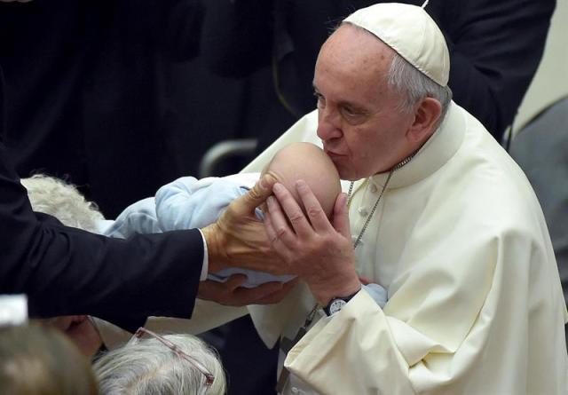 El papa Francisco (dcha) sostiene a un bebé durante una audiencia con cerca de 5.000 gitanos venidos de todo el mundo en el aula Pablo VI en el Vaticano, hoy, 26 de octubre de 2015. EFE/Ettore Ferrari