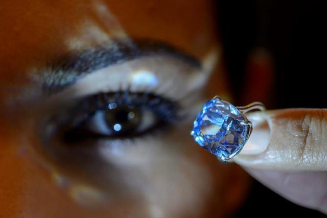 Una empleada de la casa de subastas Sotheby's muestra el "Blue Moon Diamond", en la sede de Sotheby's en Ginebra, Suiza, hoy, 4 de noviembre de 2015. La gema, de 12,03 quilates, está entre los diamantes azules más grandes que se conocen, cuyo valor estimado se sitúa entre 35 y 55 millones de dólares. La subasta de esta piedra preciosa se celebrará el próximo 11 de noviembre. EFE/MARTIAL TREZZINI