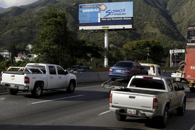 Motorists drive past a campaign billboard urging commuters to vote for MIN Unidad Party in Caracas