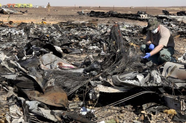 A military investigator from Russia stands near the debris of a Russian airliner at its crash site at the Hassana area in Arish city, north Egypt, November 1, 2015. Egyptian authorities have detained two employees of Sharm al-Sheikh airport in connection with the downing of a Russian jet on October 31, killing all 224 people on board, two security officials said on November 17, 2015. Picture taken November 1, 2015. REUTERS/Mohamed Abd El Ghany