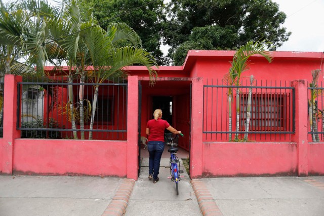 REFILE - CLARIFYING CAPTION A woman arrives at an United Socialist Party office, which is the former house of Venezuela President Hugo Chavez, in his childhood town of Sabaneta, in Barinas September 11, 2012. To understand why President Hugo Chavez may win yet another election in Venezuela next month, go and sit under the mango trees of Los Rastrojos or Sabaneta. There, in the rural villages of his childhood at the heart of Venezuela's great savannah or "llanos", family and friends pour out tales of a boy whose motor-mouth and popular touch - now mainstays of his rule - were evident early on. Picture taken September 11, 2012. To match Insight VENEZUELA-ELECTION/CHAVEZ   REUTERS/Jorge Silva (VENEZUELA - Tags: POLITICS ELECTIONS)