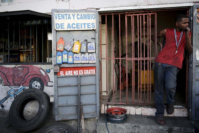 A tyre repairman waits for clients next to a sign that reads "Compressed air is not Free ", in Caracas December 2, 2015. Venezuela will hold parliamentary elections on December 6. REUTERS/Nacho Doce