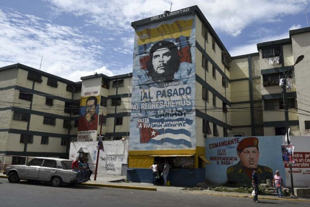 Official propaganda is seen on Caracas streets on December 4, 2015. For the first time in 16 years of "Bolivarian revolution" under late president Hugo Chavez and his successor Nicolas Maduro, polls show their rivals could now win a majority in the National Assembly. AFP PHOTO / LUIS ROBAYO / AFP / LUIS ROBAYO