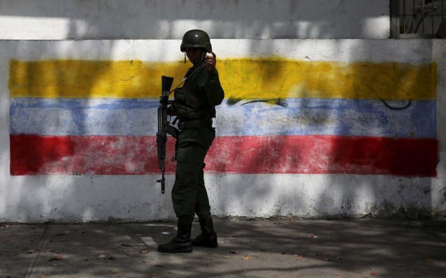 A soldier patrols outside a school which will function as a polling station in Caracas December 5, 2015. Venezuela will hold parliamentary elections on December 6. REUTERS/Nacho Doce