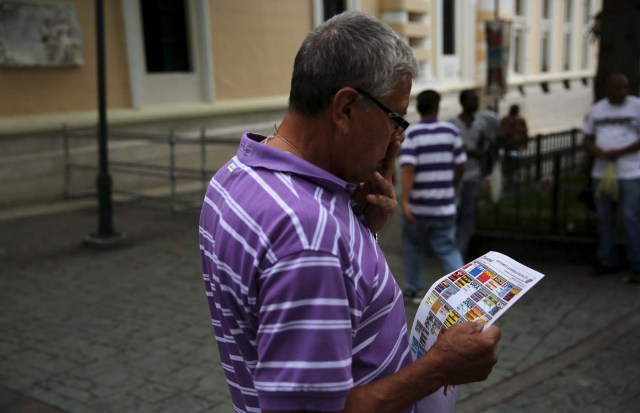 A man looks at a poster depicting a paper ballot in downtown Caracas December 5, 2015. Venezuela will hold parliamentary elections on December 6. REUTERS/Nacho Doce