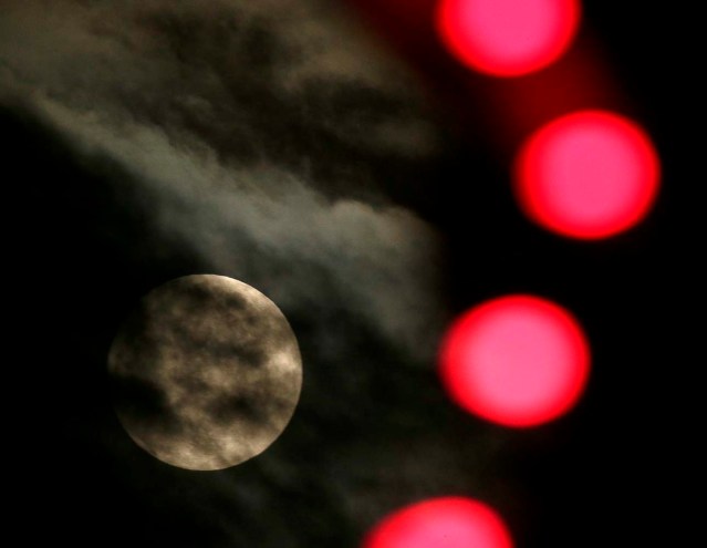 El luna casi llena se ve a través del alumbrado navideño en Leneza, Kansas, el jueves 24 de diciembre de 2015.  (AP Foto/Charlie Riedel)