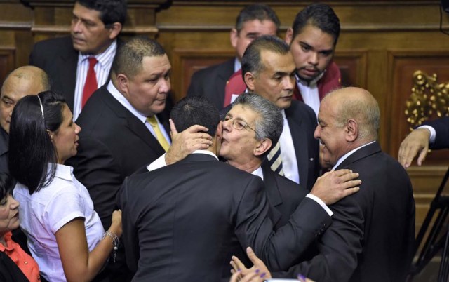 The new president of the Venezuelan parliament, deputy Henry Ramos Allup (C) is greeted by other opposition lawmakers at the parliament in Caracas, on January 5, 2016.  Venezuela's President Nicolas Maduro ordered the security forces to ensure the swearing-in of a new opposition-dominated legislature passes off peacefully Tuesday, after calls for rallies raised fears of unrest. AFP PHOTO/JUAN BARRETO / AFP / JUAN BARRETO