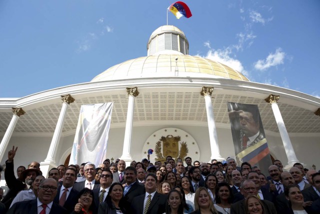 Deputies of Venezuelan coalition of opposition parties (MUD) pose for a picture in front of a giant picture of Venezuela's late President Hugo Chavez after a session of the National Assembly in Caracas January 5, 2016. REUTERS/Carlos Garcia Rawlins