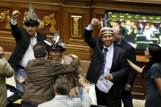 Julio Ygarza (L), Nirma Guarulla (C) and Romel Guzamana (2nd R), deputies of Venezuelan coalition of opposition parties (MUD), celebrate after their swearing-in ceremony during a session of the National Assembly in Caracas January 6, 2016. Venezuela's opposition defied a court ruling and swore into the new congress on Wednesday three lawmakers barred from taking their seats, deepening the showdown between the legislature and President Nicolas Maduro's government. REUTERS/Marco Bello TPX IMAGES OF THE DAY