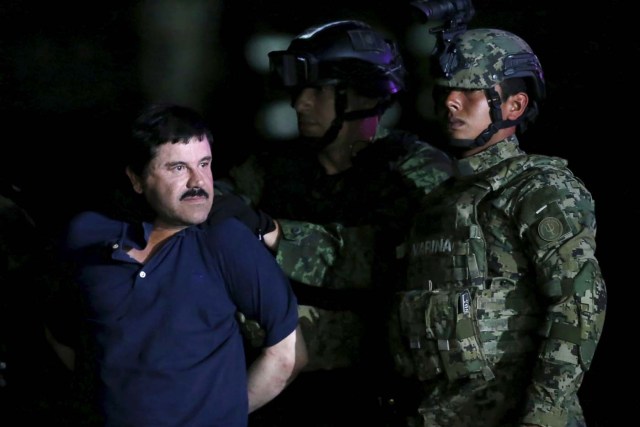 Joaquin "El Chapo" Guzman is escorted by soldiers during a presentation at the hangar belonging to the office of the Attorney General in Mexico City, Mexico January 8, 2016.  REUTERS/Edgard Garrido
