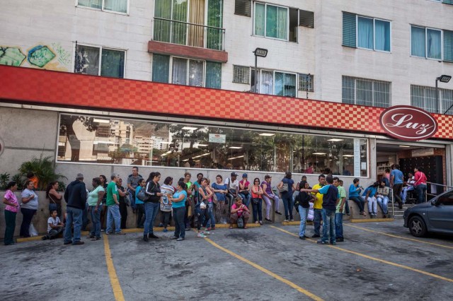 CAR01. CARACAS (VENEZUELA), 16/01/2016.- Decenas de personas hacen filas frente a un supermercado para poder comprar alimentos hoy, sábado 16 de enero de 2016, en la ciudad de Caracas (Venezuela). Venezuela, con las mayores reservas probadas de petróleo del mundo, se declaró en emergencia económica para atender la situación del país que después de un año de opacidad reveló una inflación interanual de 141,5 por ciento -la más alta de toda su historia-, y una contracción del 4,5 por ciento. EFE/MIGUEL GUTIÉRREZ