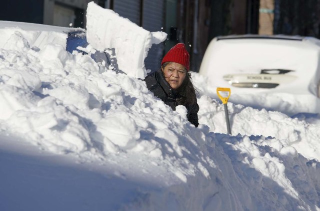A resident digs her car out from the snow in Union City, New Jersey, across the Hudson River from Midtown Manhattan, after the second-biggest winter storm in New York history, January 24, 2016. REUTERS/Rickey Rogers