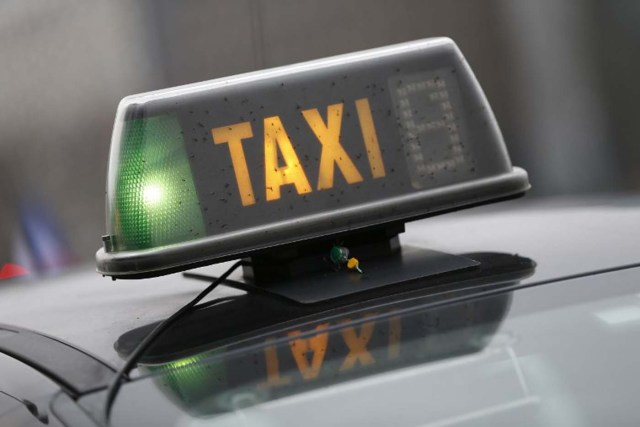 A taxi sign is pictured during a demonstration against the VTC (transport vehicle with chauffeur) on January 26, 2016 at porte Maillot in Paris. AFP PHOTO / THOMAS SAMSON / AFP / THOMAS SAMSON