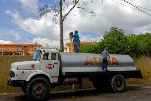 A man fills a tanker with water in Caracas on January 21, 2016. Venezuela suffers a severe water shortage, which the government attributes to the delay in the arrival of the rainy season for the third consecutive year due to El Nino weather phenomenon. AFP PHOTO/FEDERICO PARRA / AFP / FEDERICO PARRA