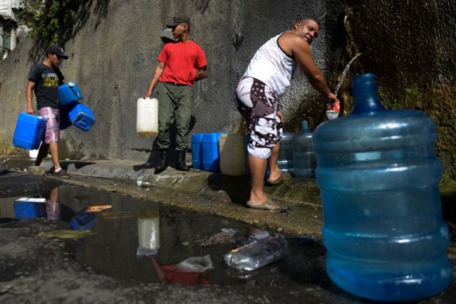 People line up to fill jerry cans with water from the Wuaraira Repano mountain in Caracas on January 21, 2016. Venezuela suffers a severe water shortage, which the government attributes to the delay in the arrival of the rainy season for the third consecutive year due to El Nino weather phenomenon. AFP PHOTO/FEDERICO PARRA / AFP / FEDERICO PARRA