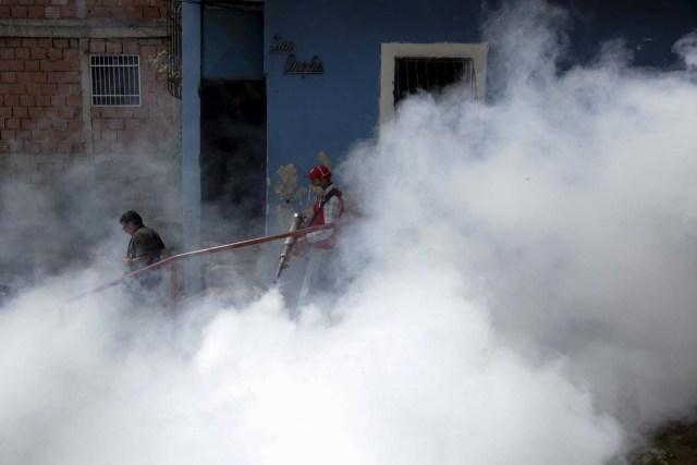 A Venezuelan health worker fumigates the Valle slum to help control the spread of the mosquito-borne Zika virus in Caracas, January 28, 2016. REUTERS/Marco Bello