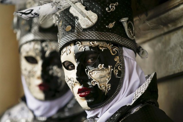 Masked revellers pose during the Venice Carnival, in Piazza San Marco January 30, 2016.  REUTERS/Alessandro Bianchi