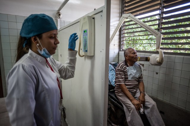 Una estudiante de odontología toma una placa de rayos X a un paciente el viernes con un equipo antiguo durante una clase de laboratorio de la UCV en Caracas. La universidad interrumpió las clases el año pasado frente a un recorte presupuestario del 70% y otros problemas. PHOTO: MIGUEL GUTIÉRREZ PARA THE WALL STREET JOURNAL.