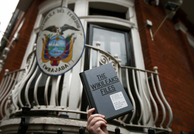 A supporter of WikiLeaks founder Julian Assange holds a copy of The WikiLeaks Files outside the Ecuadorian embassy in central London, Britain February 5, 2016. Assange should be allowed to go free from the Ecuadorian embassy in London and be awarded compensation for what amounts to a three-and-a-half-year arbitrary detention, a U.N. panel ruled on Friday.     REUTERS/Peter Nicholls  TPX IMAGES OF THE DAY