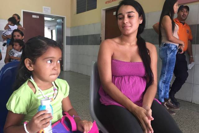 Dairy Varela, con cuatro meses de embarazo y síntomas del zika, espera recibir tratamiento médico en una clínica estatal con su hija de 3 años de edad. PHOTO: SARA SCHAEFER MUÑOZ/THE WALL STREET JOURNAL