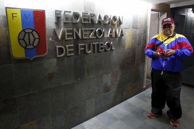 Un hombre revisa su celular afuera de la sede de la Federación Venezolana de Fútbol, en Caracas. 27 de mayo de 2015. El presidente de la Federación Venezolana de Fútbol (FVF), Laureano González, dijo el jueves que su principal patrocinante, la estatal Petróleos de Venezuela (PDVSA), no le ha pagado "ni un dólar" desde el año pasado, colocando al ente rector del balompié criollo en una situación financiera delicada. REUTERS/Carlos Garcia Rawlins