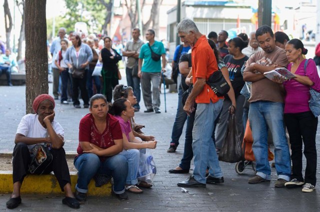 TO GO WITH AFP STORY by Valentina Oropeza and Ernesto Tovar People queue at a bakery in Caracas on February 25, 2016. On any given day, people in Venezuela can wait hours to get some subsidized milk, cooking oil, milk or flour -- if they can find any -- with some bakeries rationing their bread production and others selling no bread at all. Venezuela, which is sitting on the biggest known oil reserves from which it derives 96 percent of its foreign revenues, has been devastated by the drop in prices and is beset with record shortages of basic goods, runaway inflation and an escalating economic crisis. AFP PHOTO / FEDERICO PARRA / AFP / FEDERICO PARRA
