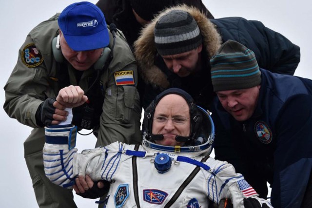 Ground personnel help International Space Station (ISS) crew member Scott Kelly of the U.S. to get out of the Soyuz TMA-18M space capsule after landing near the town of Dzhezkazgan, Kazakhstan, on March 2, 2016. US astronaut Scott Kelly and Russian cosmonaut Mikhail Kornienko returned to Earth on March 2 after spending almost a year in space in a ground-breaking experiment foreshadowing a potential manned mission to Mars. AFP PHOTO / POOL / KIRILL KUDRYAVTSEV / AFP / POOL / KIRILL KUDRYAVTSEV