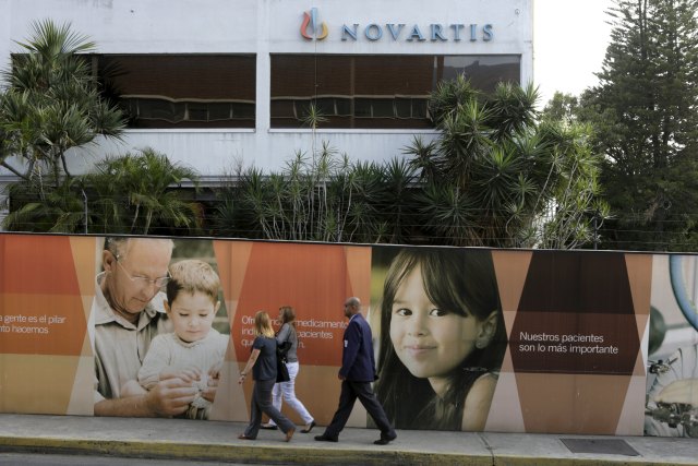 People walk in front of the Novartis headquarters building in Caracas March 1, 2016. Picture taken March 1, 2016. To match Insight VENEZUELA-PHARMACEUTICALS/ REUTERS/Marco Bello