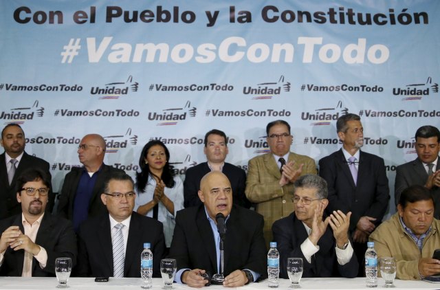 Jesus Torrealba (C), secretary of Venezuela's coalition of opposition parties (MUD), talks to the media next to his fellow politicians during a news conference in Caracas March 8, 2016. The message on the backdrop reads: "With the people and the constitution, we are going with everything". REUTERS/Carlos Garcia Rawlins