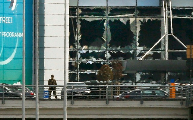 Un soldado se encuentra cerca de las ventanas rotas después de las explosiones en el aeropuerto de Zaventem, cerca de Bruselas, Bélgica, 22 de marzo de 2016. REUTERS / Francois Lenoir