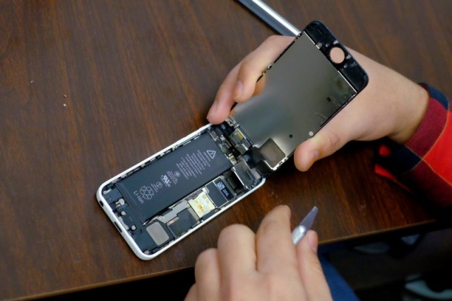 Un hombre intenta reparar un iPhone, en una tienda en Nueva York. Reuters/Eduardo Muñoz