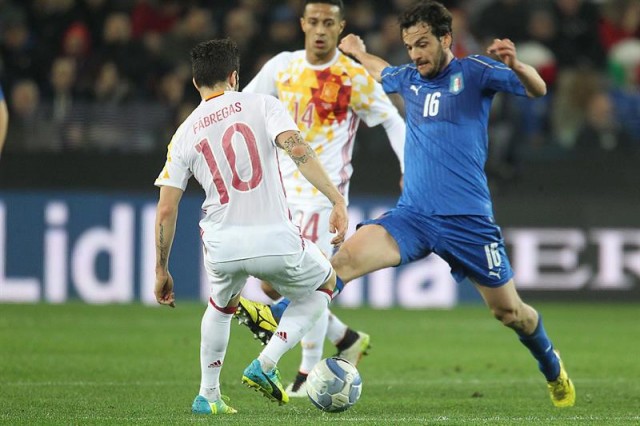 El italiano Marco Parolo (d) disputa el balón con el español Cesc Fabregas (i) entre Italia y España en el estadio Friuli de Údine (Italia). EFE
