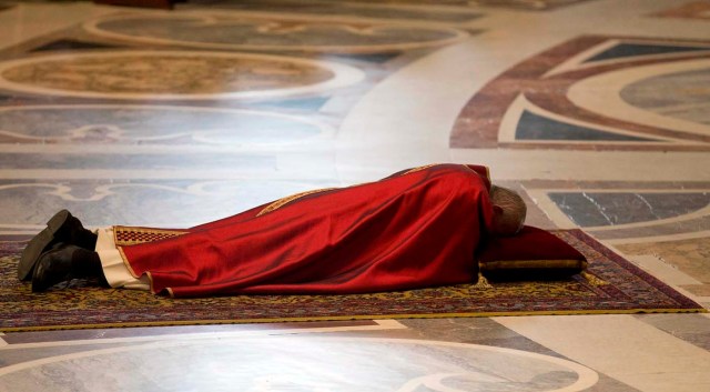 Pope Francis lies as he prays during the Celebration of the Lord's Passion in Saint Peter's Basilica at the Vatican March 25, 2016. REUTERS/Alessandra Tarantino/Pool