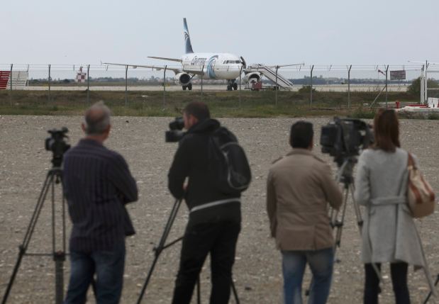 Media gather at Larnaca Airport near a hijacked Egyptair Airbus A320 , March 29, 2016. REUTERS/Yiannis Kourtoglou