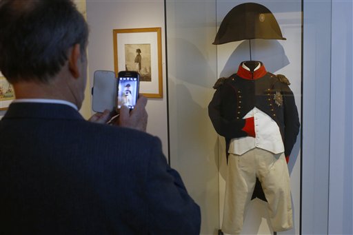 Un visitante toma fotos de un uniforme de Napoleón en la exposoción "Napoleón en Santa Helena", en París, martes 5 de abril de 2016. El museo militar nacional ha recreado la casa donde Napoleón pasó sus últimos años, al traer muebles y pertenencias de la isla atlántica de Santa Helena al centro de París por primera vez desde su exilio hace 200 años.(AP Foto/Francois Mori)