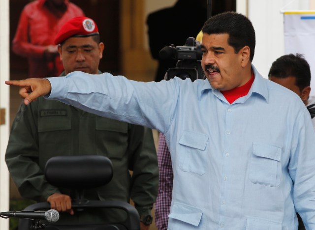 El presidente Nicolás Maduro apunta hacia sus partidarios durante una marcha frente al Palacio de Miraflores en Caracas, Venezuela, el jueves 7 de abril de 2016. Varios miles de empleados públicos y seguidores del gobierno realizaron una marcha en el centro de la capital venezolana para protestar contra la ley de amnistía que aprobó la mayoría opositora de la Asamblea Nacional. (Foto AP / Ariana Cubillos)