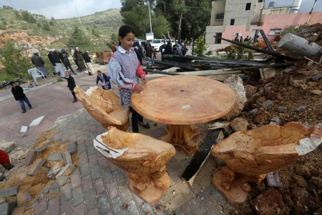 Niños palestinos comprobar la destrucción de un parque infantil, que fue construido con fondos de Bélgica, en el pueblo Zatarah, al sur de la ciudad cisjordana de Naplusa, después de que fue demolido el 12 de abril, 2016 autoridades israelíes que dijeron que era construir en la denominada zona C, una zona militar cerrada en la que Israel ejerce un control total. Israel a menudo destruye los edificios construidos sin los permisos requeridos israelíes en la zona C de Cisjordania, que está bajo control israelí. JAAFAR ASHTIYEH / AFP