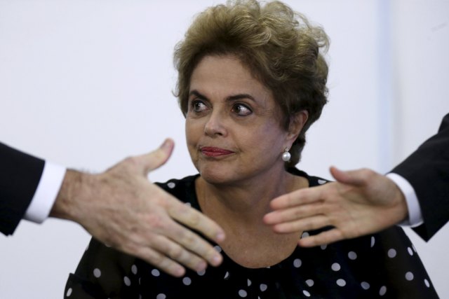 La presidenta de Brasil, Dilma Rousseff, observa durante una ceremonia en el Palacio de Planalto en Brasilia. 13 de abril de 2016. Rousseff prometió el miércoles formar un Gobierno de unidad nacional si sobrevive a una votación de juicio político el fin de semana en el Congreso, pero las posibilidades en su contra aumentaron debido a que el respaldo de los aliados que le quedaban comenzó a menguar.REUTERS/Ueslei Marcelino