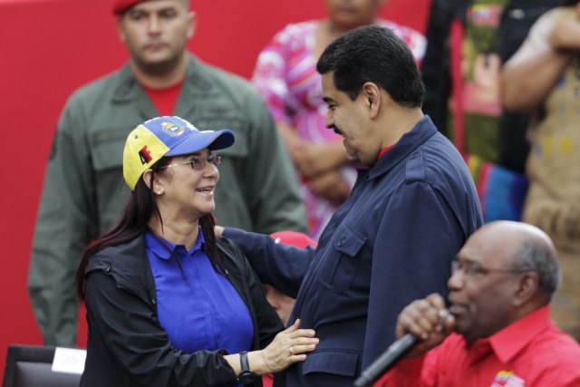 Venezuela's President Nicolas Maduro talks to his wife and deputy of Venezuela's United Socialist Party (PSUV) Cilia Flores (L) as they arrive to a rally against the opposition's law granting titles of property to beneficiaries of Mission Housing, a low-income social housing project, in Caracas April 14, 2016. REUTERS/Marco Bello