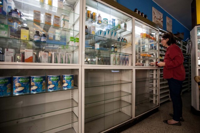 ACOMPAÑA CRÓNICA: VENEZUELA SALUD CAR38. CARACAS (VENEZUELA), 14/04/2016.- Beatriz Gorostiza, una de las encargadas de la farmacia "San Vicente", busca medicamentos en un estante este, jueves 14 de abril del 2016, en la ciudad de Caracas (Venezuela). La escasez de medicamentos en Venezuela sigue siendo una tragedia visible en farmacias y hospitales, semanas después de que el Parlamento declarara una "crisis humanitaria de salud" que, entre otros cosas, se estaría manifestando en la falta de disponibilidad de 872 fármacos esenciales. EFE/MIGUEL GUTIÉRREZ