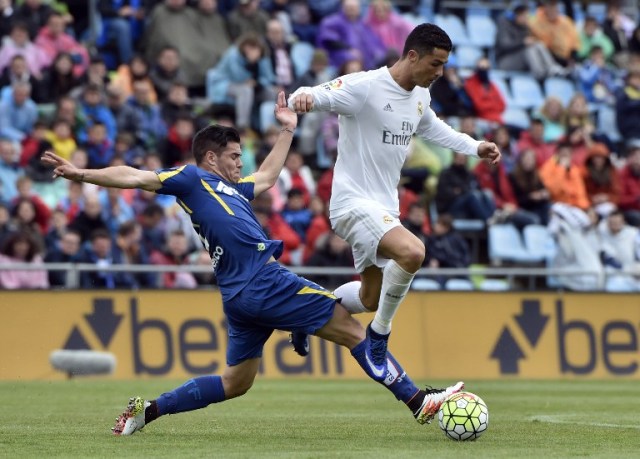 Getafe's defender Buendia (L) vies with Real Madrid's Portuguese forward Cristiano Ronaldo during the Spanish league football match Getafe CF vs Real Madrid CF at the Coliseum Alfonso Perez stadium in Getafe on April 16, 2016. / AFP PHOTO / GERARD JULIEN