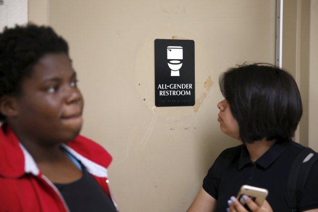 Kween Robinson, 17, (L) and Juliet Dominguez, 15, stand in front of the first gender-neutral restroom in the Los Angeles school district, which they helped lobby for, at Santee Education Complex high school in Los Angeles, California, U.S., April 18, 2016. REUTERS/Lucy Nicholson