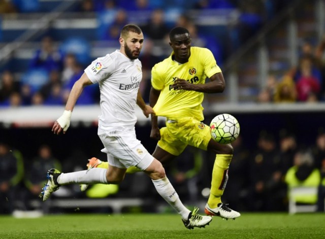 Real Madrid's French forward Karim Benzema (L) vies with Villarreal's Ivorian defender Eric Bally during the Spanish league football match Real Madrid vs Villarreal at the Santiago Bernabeu stadium in Madrid on April 20, 2016. / AFP PHOTO / PIERRE-PHILIPPE MARCOU