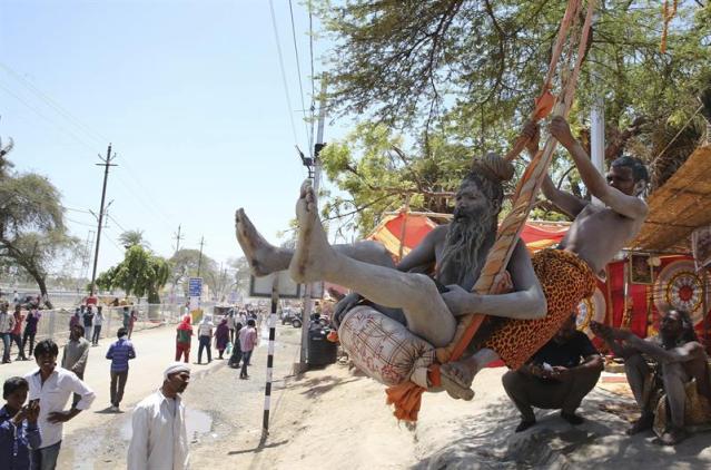 Dos Naga Sadhus o ascetas hindús se montan en un columpio durante el festival de Kumbh Mela en Ujjain, a unos 180 km de Bhopal (India) hoy, 21 de abril de 2016. El festival se celebra del 22 de abril al 22 de mayo. EFE/Sanjeev Gupta