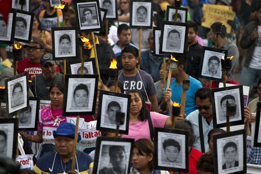 Familiares de 43 profesores de magisterio desaparecidos sostienen imágenes de los jóvenes, en una protesta para exigir que no se cierre el caso y que se sigan las recomendaciones de los expertos sobre nuevas pistas, en Ciudad de México, el martes 26 de abril de 2016. (AP Foto/Rebecca Blackwell)