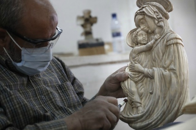 Un artesano palestina talla una escultura de madera de la Virgen María en el taller de los hermanos zacharia 'en la ciudad cisjordana de Belén, el 28 de abril de 2016, pocos días antes de los cristianos ortodoxos celebran la Pascua. THOMAS COEX / AFP