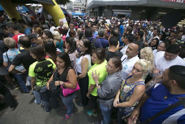 Personas que hacen fila para firmar una petición, organizada por la oposición, para iniciar un referendo revocatorio del mandato del presidente de Venezuela Nicolás Maduro en Caracas, Venezuela, el miércoles 27 de abril de 2016. (AP Photo/Ariana Cubillos)