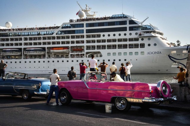 Cubans watch as the first US-to-Cuba cruise ship to arrive in the island nation in decades glides into the port of Havana, on May 2, 2016.  The first US cruise ship bound for Cuba in half a century, the Adonia -- a vessel from the Carnival cruise's Fathom line -- set sail from Florida on Sunday, marking a new milestone in the rapprochement between Washington and Havana. The ship -- with 700 passengers aboard -- departed from Miami, the heart of the Cuban diaspora in the United States. / AFP PHOTO / ADALBERTO ROQUE